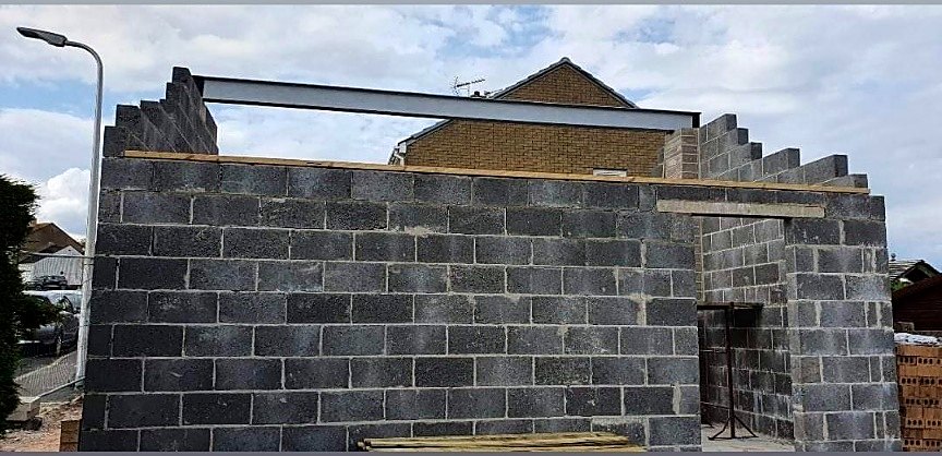Blockwork shell with a steel beam spanning the opening and timber wall plates in position