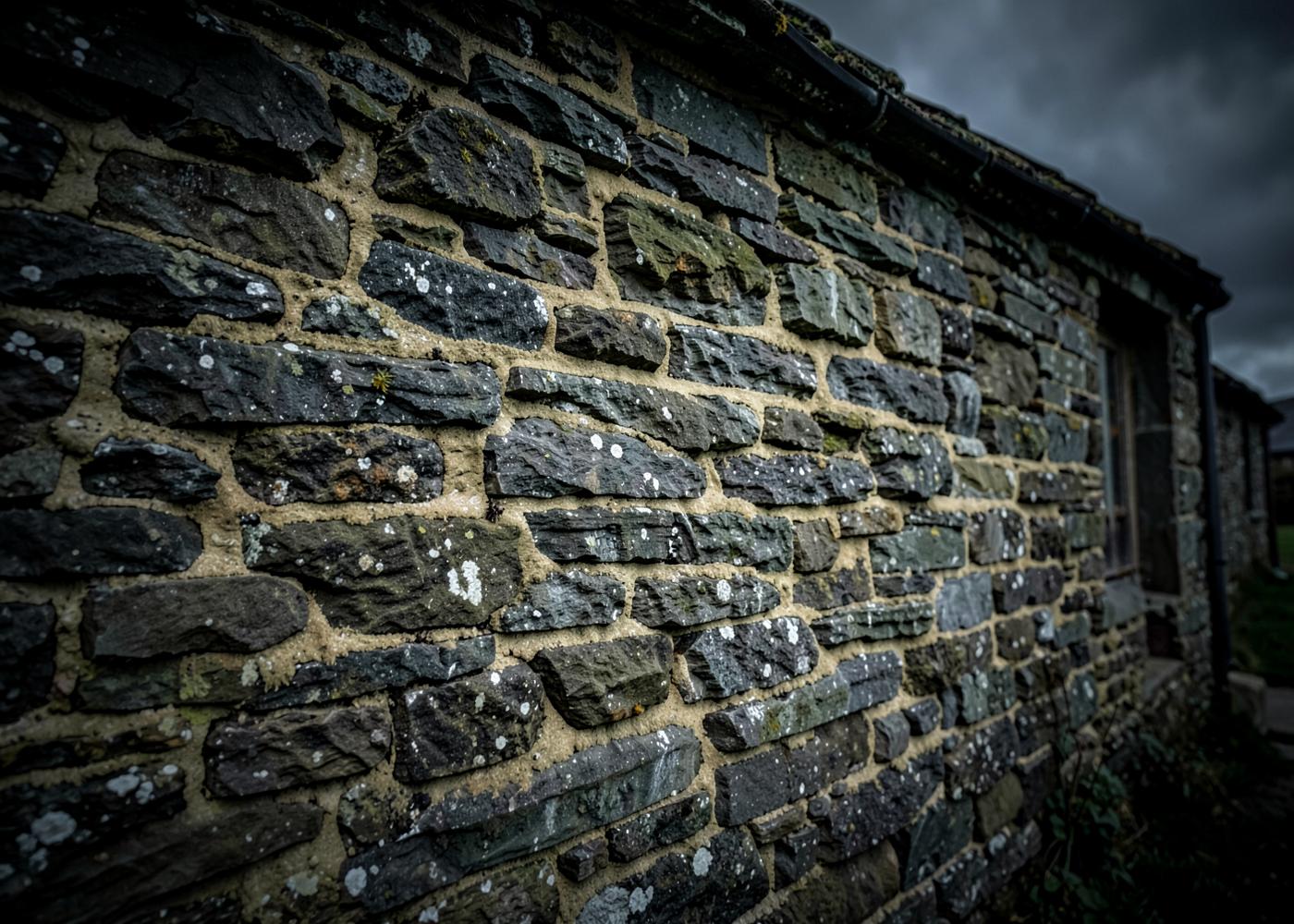 Traditional Cumbrian stone wall with lime mortar on an old farm building